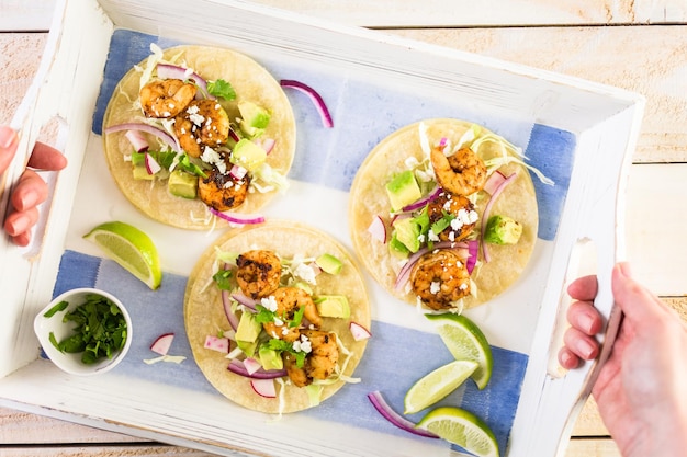 Tacos de camarão com chipotle fresco com queijo cotija em uma tortilhas de milho branco.