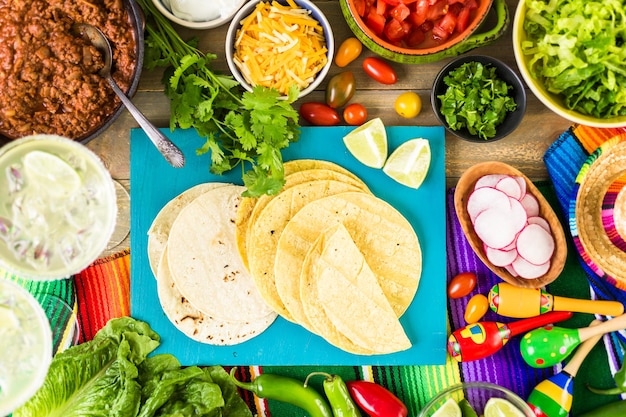 Tacos de carne moída com alface, tomate picado, rabanete e queijo cheddar ralado.