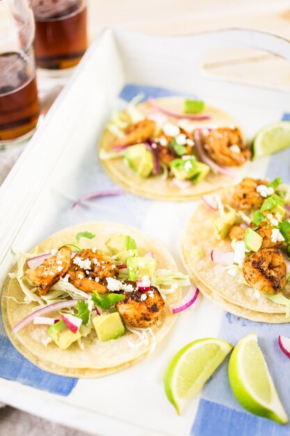 Tacos frescos de camarones chipotle con queso cotija sobre tortillas de maíz blanco.