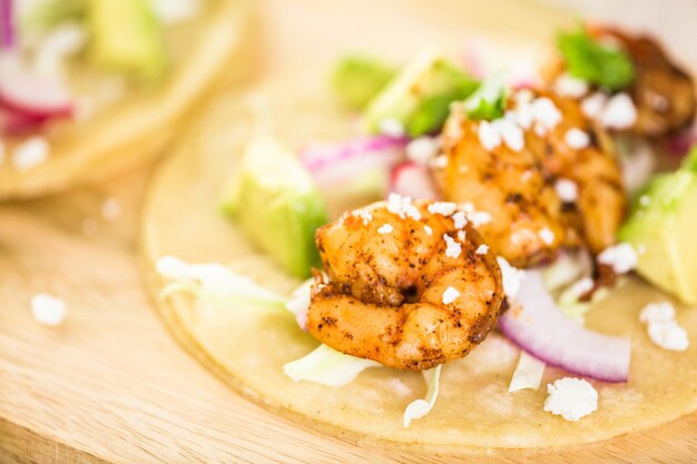 Tacos frescos de camarones chipotle con queso cotija sobre tortillas de maíz blanco.