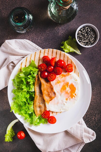 Foto tacos grelhados com ovos fritos, legumes e ervas em um prato e vista vertical