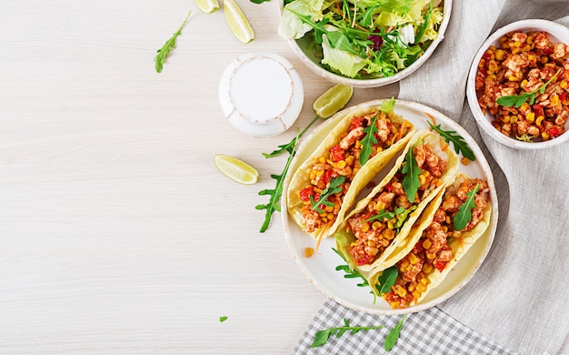 Tacos mexicanos con carne de pollo, maíz y salsa de tomate.