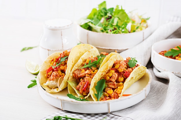 Tacos mexicanos con carne de pollo, maíz y salsa de tomate.