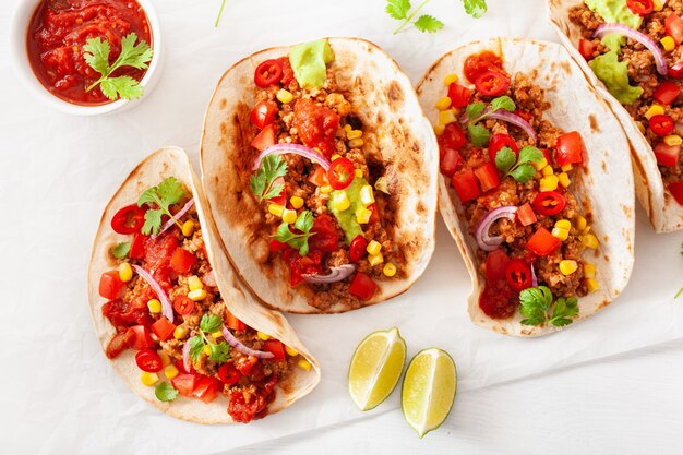 Tacos mexicanos de carne de res y cerdo con salsa, guacamole y vegetales