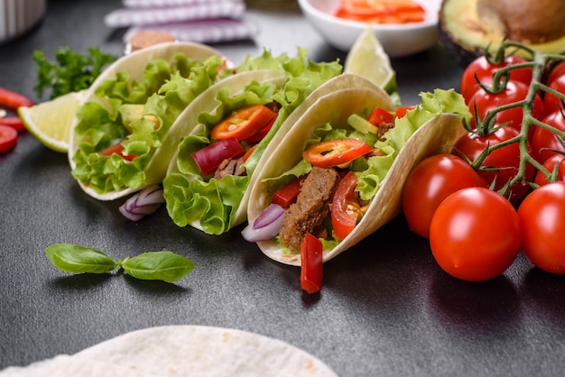 Tacos mexicanos con carne de res, tomate, aguacate, cebolla y salsa salsa