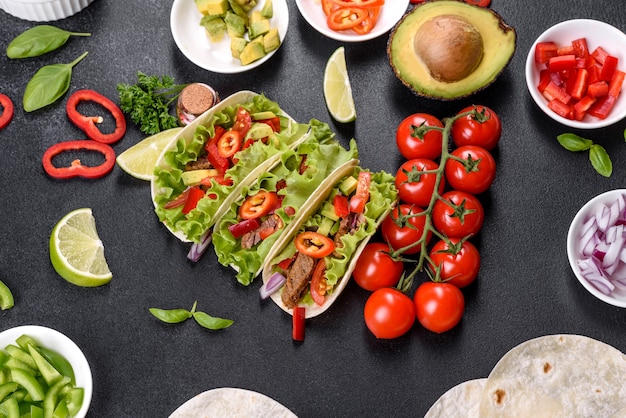 Tacos mexicanos con carne de res, tomate, aguacate, cebolla y salsa salsa