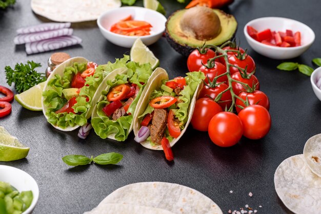 Tacos mexicanos con carne de res, tomate, aguacate, cebolla y salsa salsa