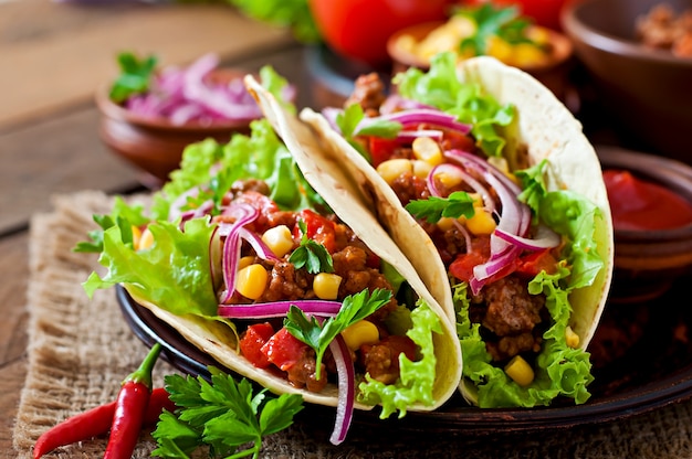 Tacos mexicanos con carne, verduras y cebolla roja.