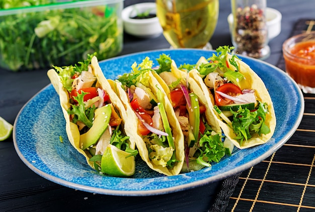 Tacos mexicanos com carne de frango, abacate, tomate, pepino e cebola vermelha. Tortilha saudável. Enrole a comida. Taco