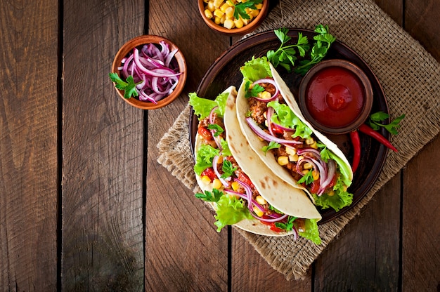 Tacos mexicanos com carne, legumes e cebola vermelha