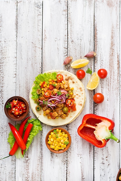 Tacos mexicanos com carne, milho e azeitonas em fundo de madeira. Vista do topo