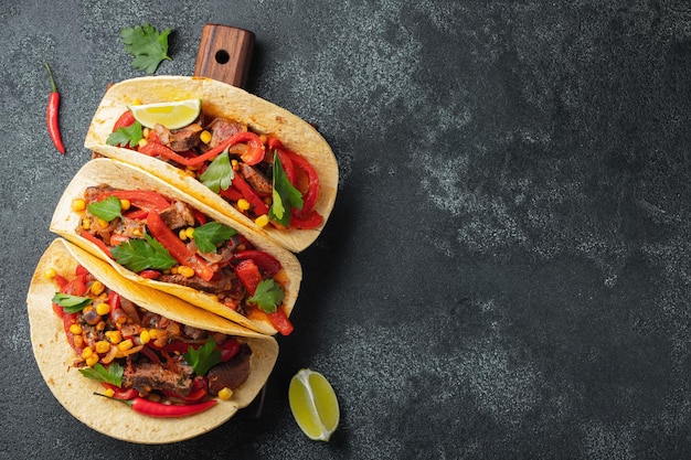 Tacos mexicanos com vegetais de carne bovina e salsa Tacos al pastor em tábua de madeira em fundo preto