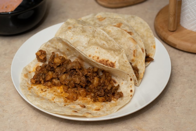 Tacos mexicanos em um prato branco na mesa da cozinha