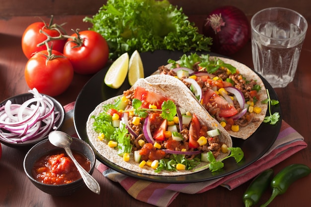 Tacos mexicanos con salsa de tomate, carne de res, cebolla, maíz