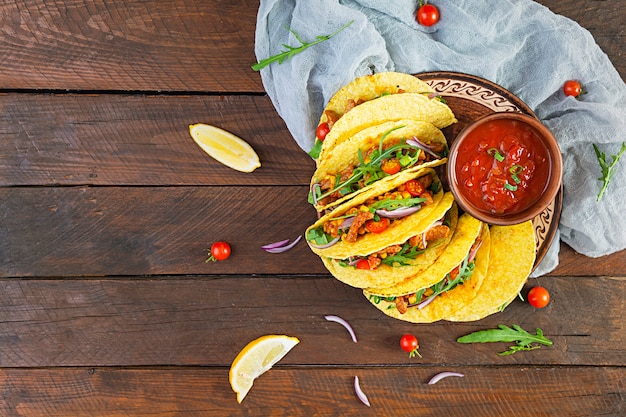 Tacos mexicanos con tortilla de maíz y carne en mesa de madera. Vista superior