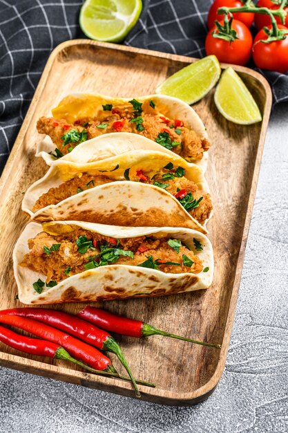 Tacos mexicanos tradicionais com salsa, queijo e pimenta. Fundo branco.