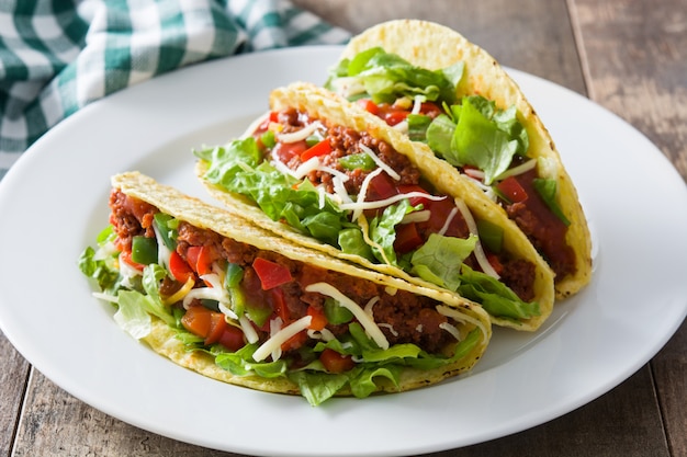 Tacos mexicanos tradicionales con carne y verduras en madera