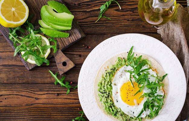 Tacos mit Guacamole, Spiegelei und Rucola. Gesundes Essen. Nützliches Frühstück. Flach legen Draufsicht