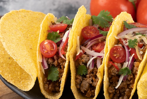 Tacos rellenos de ternera picada tomates cebolla queso y cilantro Enfoque selectivo