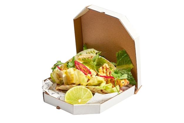 Tacos con salsa blanca de gambas y lechuga en una caja de fondo blanco