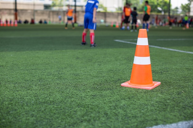 Tácticas de balón de fútbol en campo de hierba con cono para entrenamiento de fondo Formación de niños en la academia de fútbol