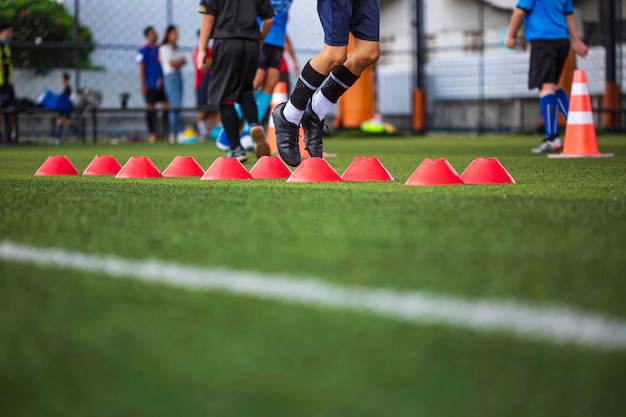 Tácticas de pelota de fútbol en campo de hierba con barrera para entrenar a los niños saltando