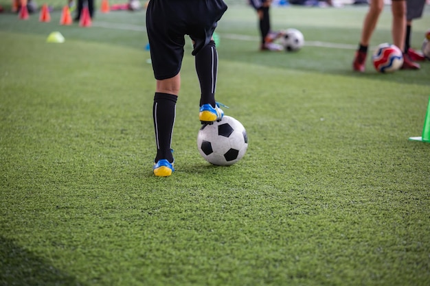 Tácticas de pelota de fútbol de niños en campo de hierba con cono