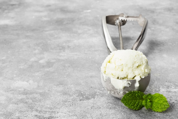 Tadellose Eiscreme im Löffel auf einem grauen Hintergrund.