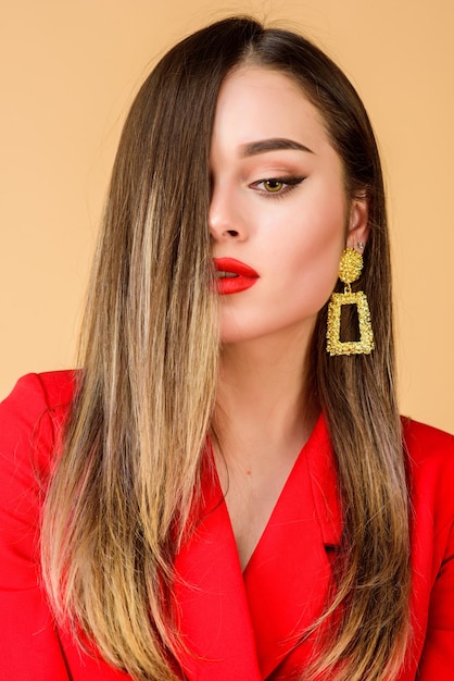 Tadelloses Make-up und perfekter Schmuck Frau trägt glamouröse Ohrringe Modetrend Juweliergeschäft Mädchenmodell langes Haar demonstriert goldene Schmuckohrringe Teures Accessoire Modischer Schmuck