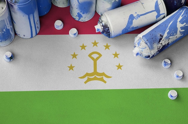 Tadschikistan-Flagge und wenige verwendete Aerosol-Sprühdosen für Graffiti-Malerei-Street-Art-Kulturkonzept