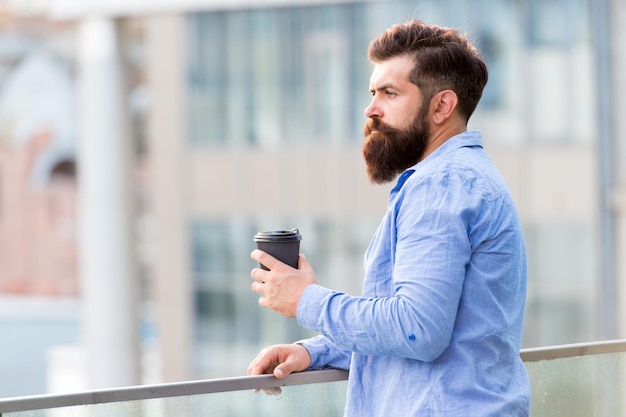 Tägliche Rituale Morgenkaffee-Konzept Koffein-Energieladung Mann trinkt Kaffee zum Mitnehmen im Freien urbaner Hintergrund Für den neuen Tag eingerichtet Persönliche Effizienz Guy bärtiger Hipster, der allein Kaffee genießt