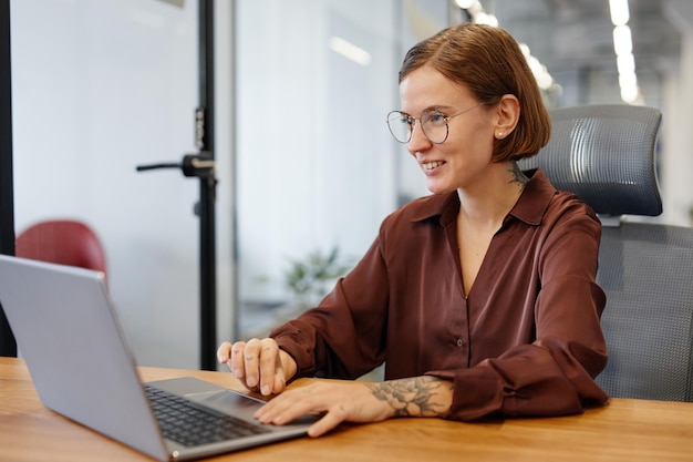 Tätowierte Frau mit Computer im Büro