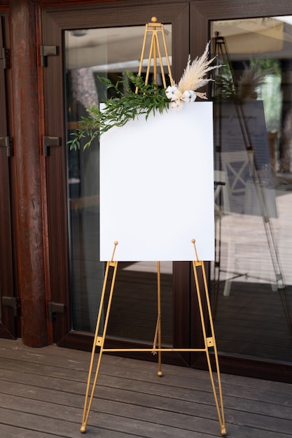 Foto tafel, die mit hochzeitsinschrift auf dem gras steht. mockup für einladung