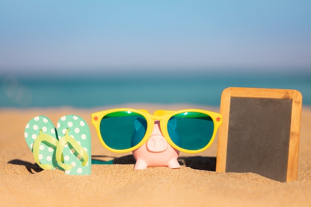 Tafel leer und Sparschwein am Sandstrand