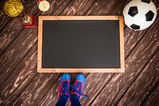 Tafel mit gezeichneter Fußballspielstrategie. Ball, Pokal und Medaille