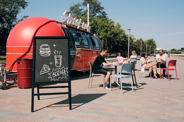 Tafel mit Rabattansage gegen Café im Freien