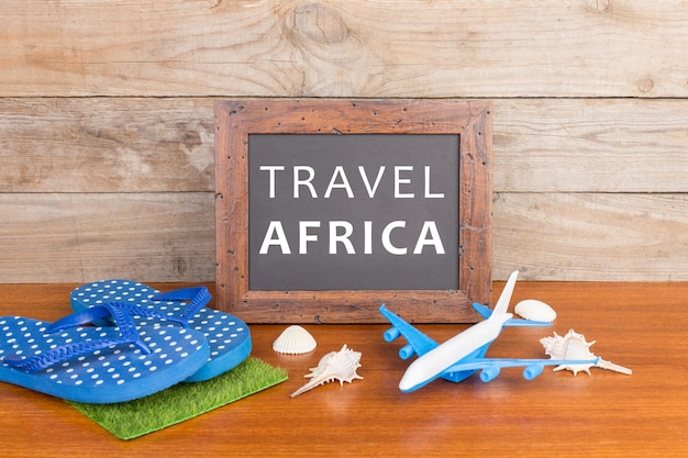 Tafel mit Text Travel Africa Flugzeug floppt Muscheln