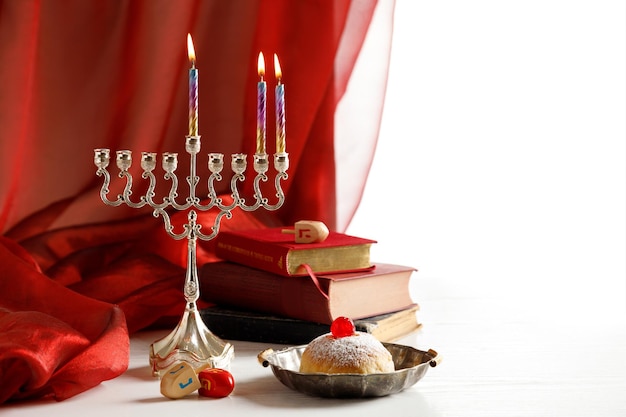Tag 2 des jüdischen religiösen Feiertags Chanukka mit Feiertag Chanukka (traditioneller Kandelaber), Kreiselspielzeug (Dreidel), Donut, religiöse Bücher (Tanakh)