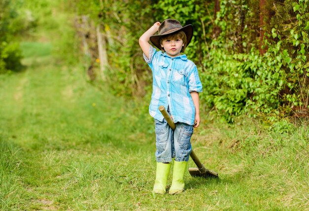 Tag der Erde. Öko-Leben. Sommeraktivität. kleiner Kindergärtner, der Spaß hat. Mensch und Natur. Landwirtschaft und Ackerbau. glückliches kinderbauernspiel mit gartenschaufel, frühling. Für immer jung und frei.