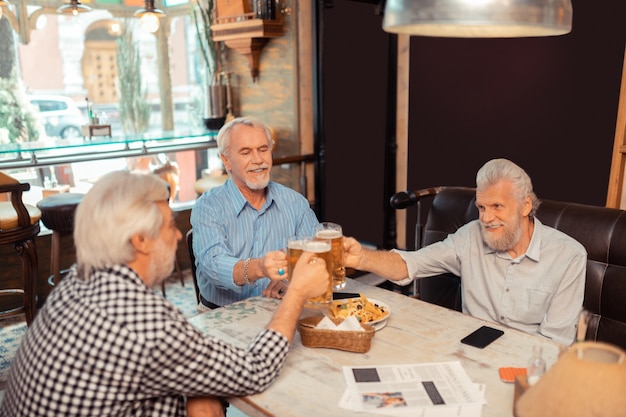 Tag der Freundschaft. Männer im Ruhestand feiern den Tag der Freundschaft beim Biertrinken in der Kneipe