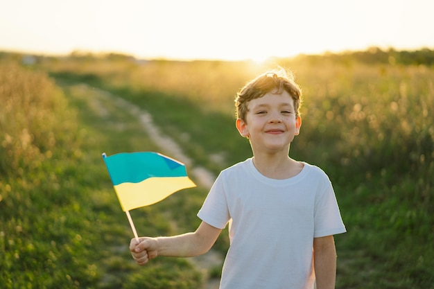 Tag der Unabhängigkeit der Ukraine Ukrainischer Kindjunge im weißen T-Shirt mit gelber und blauer Flagge der Ukraine im Feld Flagge der Ukraine Tag der Verfassung Stehen Sie mit der Ukraine Save Ukraine