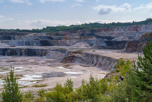 Tagebau-Steinbruch mit Maschinen und Bergbaumaschinen Kalksteinabbau zur Zementherstellung