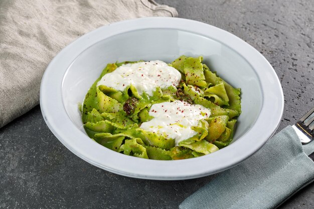 Foto tagilatelle pasta spinach green en plato blanco sobre espacio de copia de fondo de hormigón