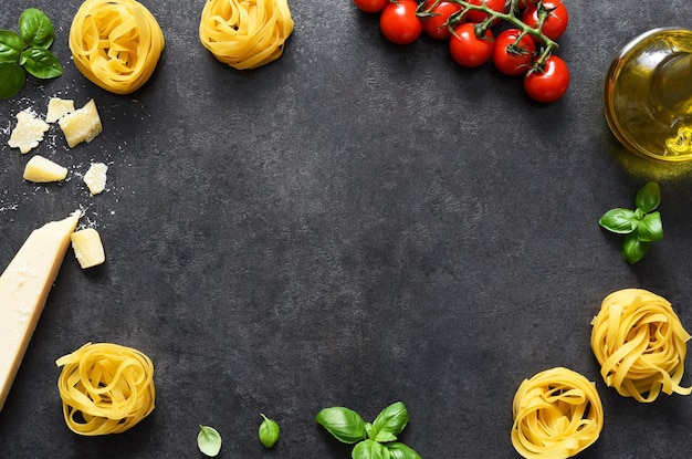 Tagliatele Nudeln, Tomaten, Basilikum und Parmesan auf schwarzem Beton