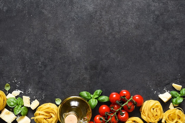 Tagliatele Nudeln, Tomaten, Basilikum und Parmesan auf schwarzem Beton