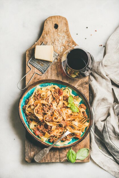 Tagliatelle boloñesa con carne picada y copa de vino tinto