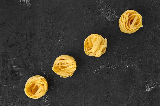 Tagliatelle crudo sobre una mesa negra