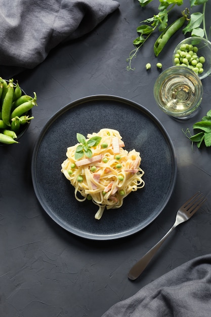 Tagliatelle da massa com creme, ervilhas e bacon. Delicioso almoço mediterrânico.