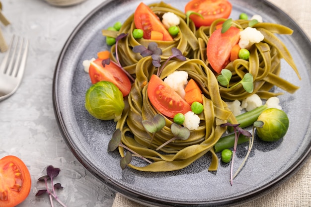 Tagliatelle grüne Spinatnudeln mit Tomaten, Erbsen und mikrogrünen Sprossen