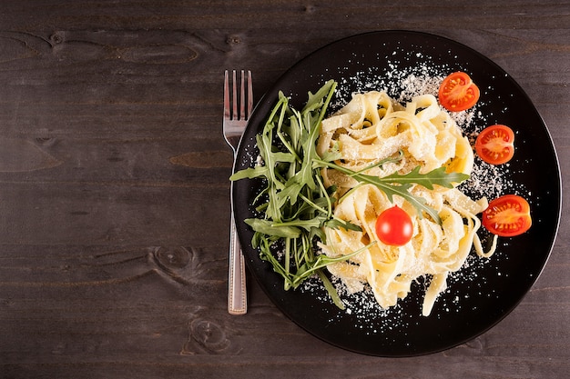 Tagliatelle-Nudeln mit Mozzarella-Käse auf Holztisch